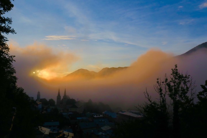 Sonnenuntergang über dem Dorf und den Bergen