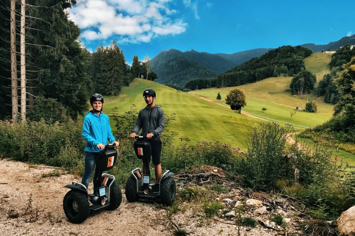 Frau und Mann auf Segways auf einem Feldweg