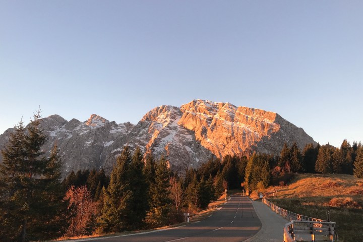 Aussicht auf eine Straße, auf Bäume und auf eine Berglandschaft